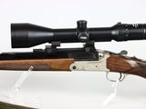 a close up of a rifle with a scope on a white background