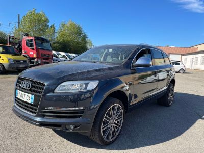 L'Audi QX est garée sur un parking, avec d'autres voitures en arrière-plan.