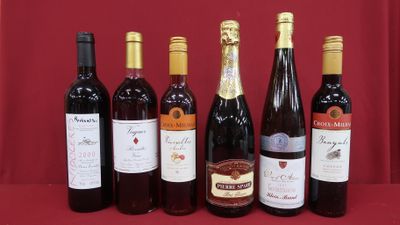 several bottles of wine are lined up on a red table