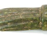 un gros plan d'un objet vert sur une surface blanche
