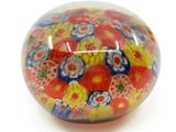 a colorful glass ball with flowers on it on a white surface