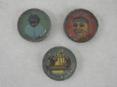 trois boutons de couleurs différentes sur lesquels figurent l'image d'un homme et d'une femme