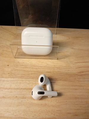 une paire d'AirPods posée sur une table à côté d'une boîte transparente