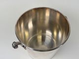 a silver metal bucket with a handle on a white surface