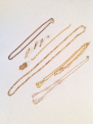 une collection de colliers et de bracelets en or posés sur un fond blanc