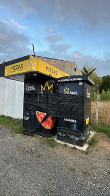 a black trash can with a pizza on it next to a white fence