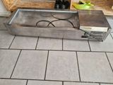 a metal sink sitting on a tiled floor in a kitchen