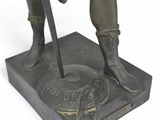 bronze statue of a man with a sword and shield on a base