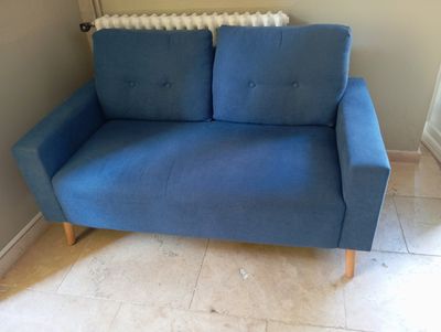 a blue couch that is sitting in the corner of a room