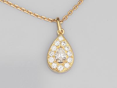 un collier en or jaune orné d'un pendentif en forme de larme serti d'un diamant