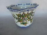 a blue and white bowl with flowers and leaves on it