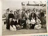a group of people posing for a picture on the deck of a ship