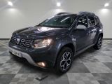La Dacia grise est garée dans une pièce au sol carrelé.