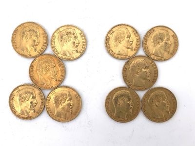 several gold coins are arranged in a row on a white surface