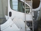 une camionnette blanche contre laquelle est appuyée une échelle