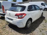 a small white car parked in a lot next to a white van