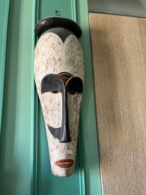 un masque accroché au mur d'une maison