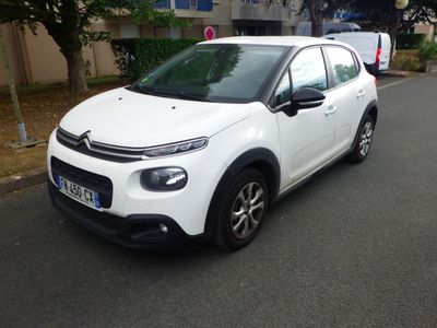 la petite voiture blanche est garée sur le bord de la route