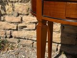 a wooden table with a drawer on it in front of a stone wall