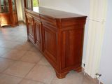 an image of a kitchen with tile flooring and wooden cabinets