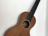 a small guitar that is sitting on a white surface
