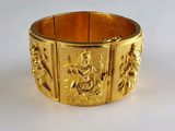 gros plan d'un bracelet en or sur une surface blanche