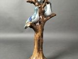une figurine représentant deux oiseaux perchés sur une branche d'arbre
