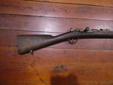an old gun that is on the wall in a room