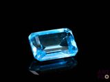 a blue topazte gems on a black surface