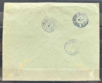 une vieille enveloppe sur laquelle sont collés trois timbres, posée sur une table