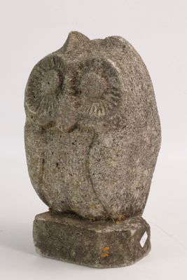 a stone sculpture of an owl sitting on a rock