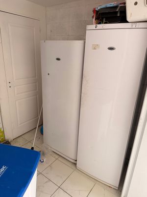 un réfrigérateur blanc et une poubelle bleue dans une cuisine