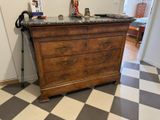 a dresser with a marble top in a room with a checkered floor