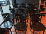 de nombreuses chaises noires dans une pièce dotée d'une grande fenêtre
