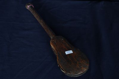 une raquette en bois avec une étiquette, posée sur un tissu bleu
