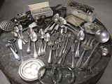 a lot of silver spoons and utensils on a table