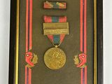 une photo encadrée représentant une médaille entourée d'un ruban
