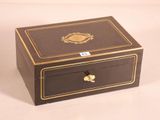 a small wooden box with a gold decoration on it