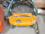 une roue jaune à laquelle est raccordé un tuyau, dans un garage