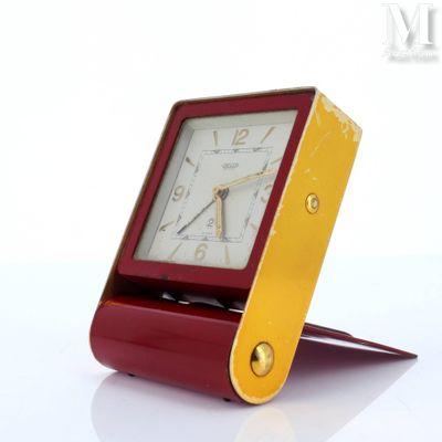 a red and gold clock sitting on top of a table