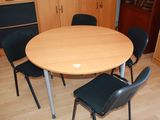 a round table with four chairs around it in a room