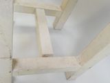 une table blanche avec un plateau en bois posée sur un sol blanc