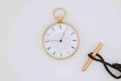 a gold pocket watch and a rope tied to it