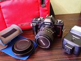 un appareil photo, un flash, un étui pour appareil photo et une lampe de poche posés sur une table