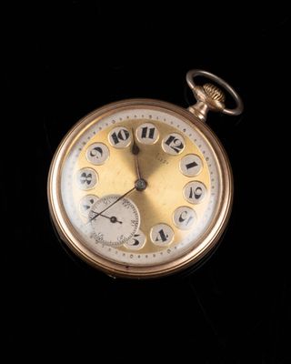 gros plan d'une montre de poche sur une surface noire