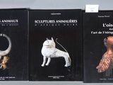 trois livres sur une étagère sur laquelle se trouvent un chien et un chat