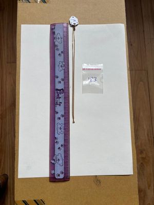 une feuille de papier sur laquelle est posé un ruban violet