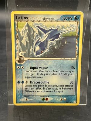 une carte Pokémon dans une boîte en plastique posée sur une table