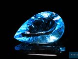 a close up of a blue diamond on a black surface