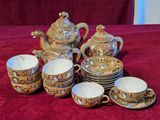 many cups and saucers on a red table cloth